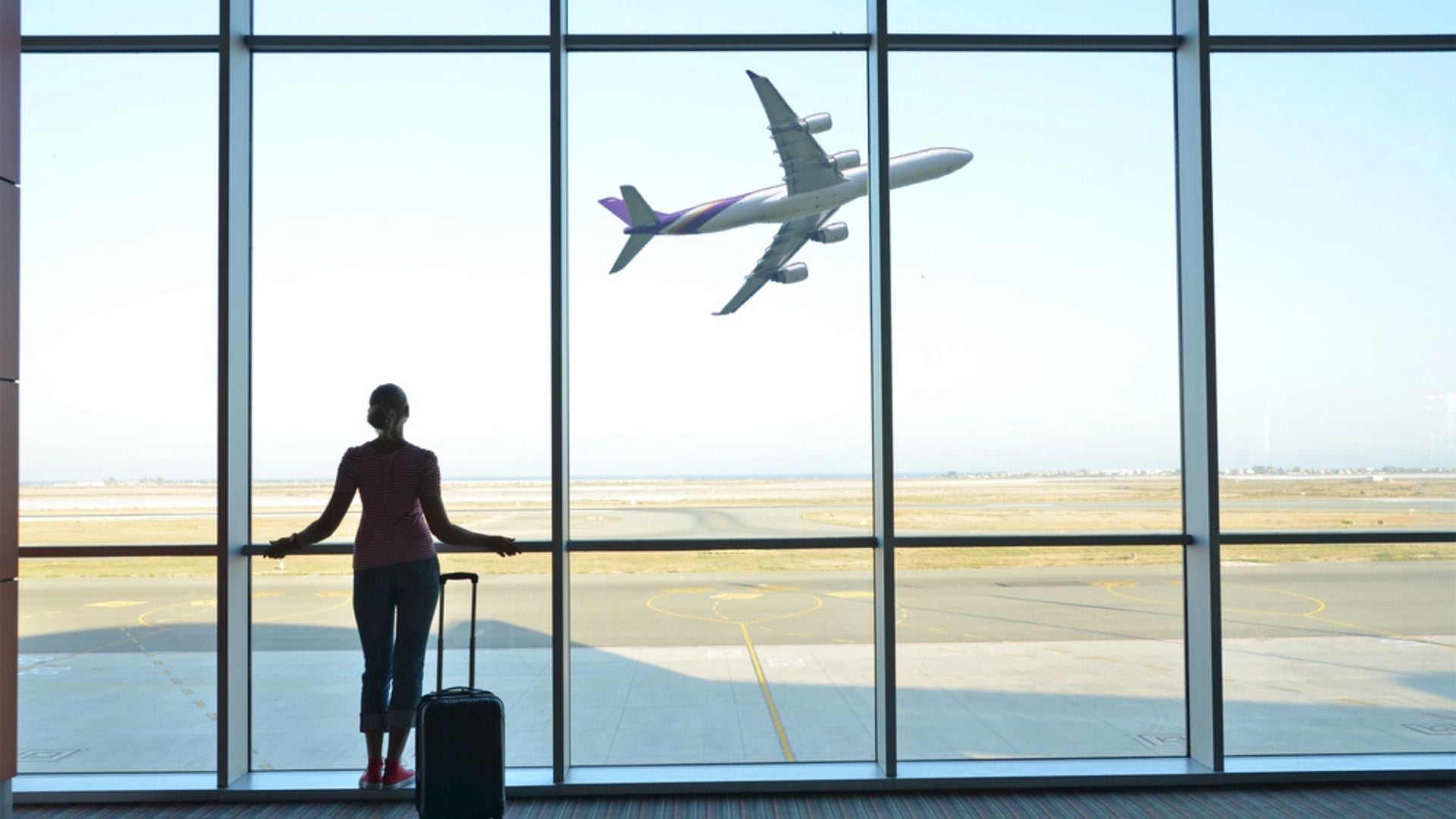 femme regardant un avion decoller